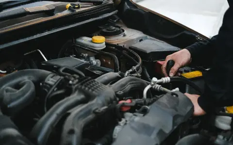 Mechanik pracuje przy silniku, sprawdzając, czy sucha miska olejowa jest szczelna.