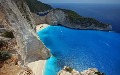 Widok na zatokę wraku Zakynthos z klifu. Turkusowa woda, biała plaża i wrak statku.