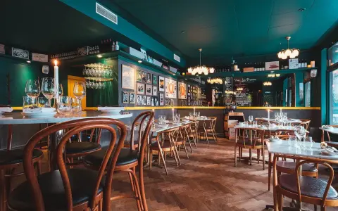 Mysig sydamerikansk restaurang i Stockholm med mörkt gröna väggar, trägolv och dukade bord.