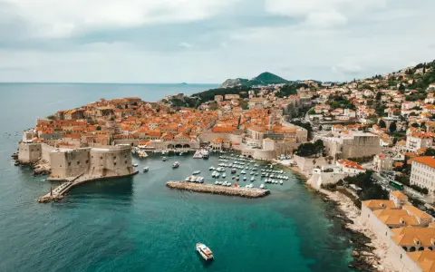 Aerial view of Dubrovnik's historic walled city and harbor, a beautiful destination for a gay vacation.