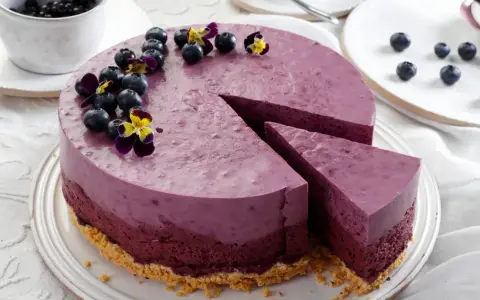 Ein wunderschöner Kuchen zum Muttertag, dekoriert mit frischen Blaubeeren und Veilchen.