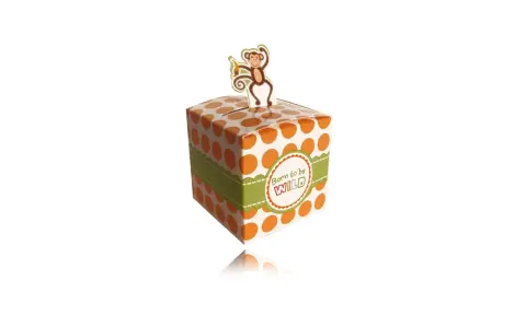 A white gift box with orange polka dots and a green ribbon, topped with a monkey cutout.