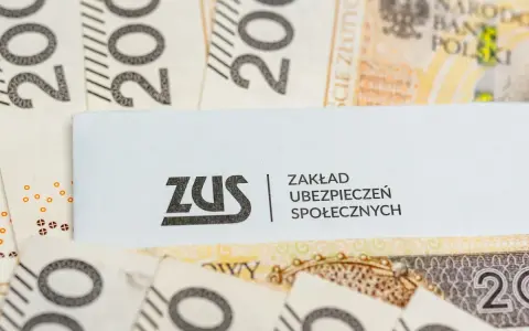 Logo ZUS na tle polskich banknotów 200 zł.