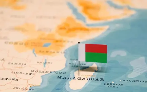 Flaga Madagaskaru na mapie. Widoczna jest Afryka i wyspa, gdzie leży Madagaskar, obok Mozambiku.