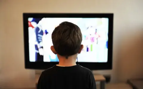 Un jeune enfant de 2 ans, absorbé par un dessin animé coloré sur le téléviseur.