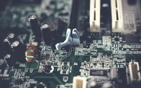 Fragment płyty głównej w formacie extended ATX z widocznymi kondensatorami, cewką i złączami.
