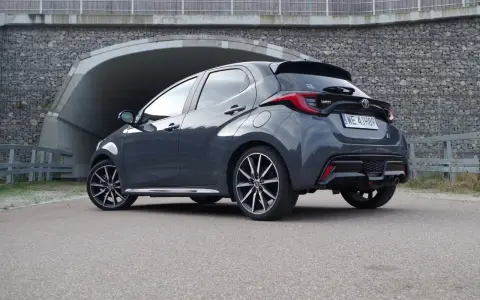 Szary Toyota Yaris Hybrid stoi przed tunelem. Dowiedz się, ile pali Toyota Yaris Hybrid, analizując jego osiągi.