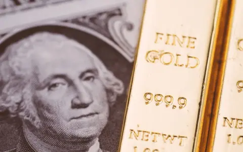 Lingotto d'oro accanto a un dollaro, evocando il gold standard significato.