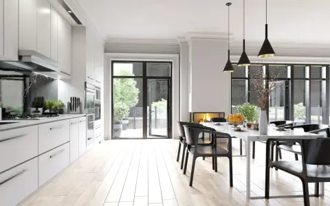 Cocina moderna con encimera de mármol negro y **suelos para cocinas sin obras** de madera clara. Mesa de comedor con sillas negras y chimenea.