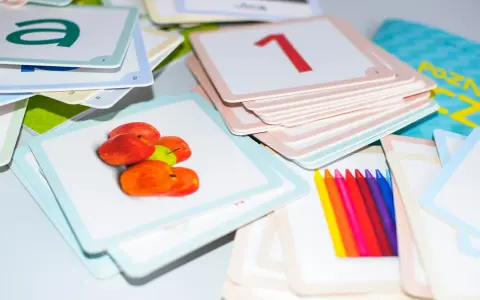 Kolorowe karty edukacyjne z literą "a", jabłkami, cyfrą "1" i kredkami. Zestaw do nauki, który pomaga dziecku, gdy kończy alfabet.