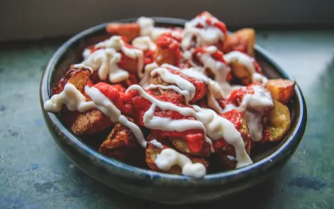 En skål med krispiga patatas bravas, toppade med en kryddig tomatsås och krämig aioli.