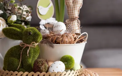 Zielony, mchowy zajączek i pisanki tworzą najpiękniejsze dekoracje wielkanocne. W koszyku jajko z napisem "Happy Easter".