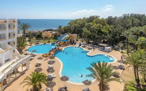Basen z wodnymi zjeżdżalniami i palmami przy hotelu, idealne miejsce na wakacje. Wiele osób korzysta z uroków tego miejsca, co potwierdzają pozytywne marhaba club opinie.