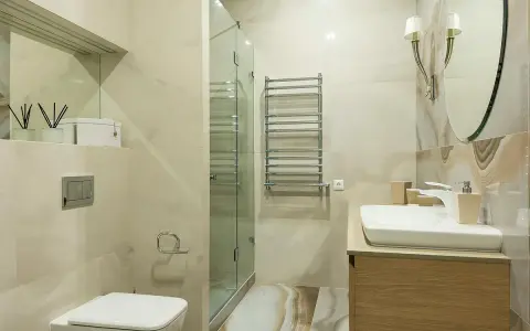 Baño moderno con ducha de cristal, lavabo y WC. Ideal para instalar extractor baño y mantener el ambiente fresco.