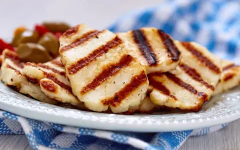 Grillowany ser halloumi na talerzu, z widocznymi paskami z grilla. Idealny dodatek do sałatek, z niską zawartością halloumi kcal.