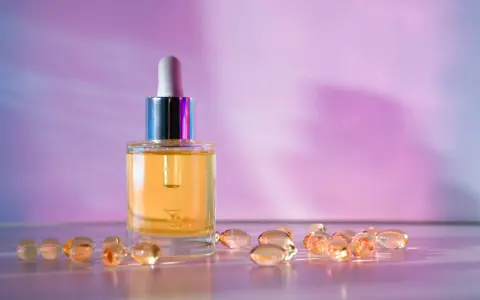 Serum z retinolem i kapsułki z retinalem na fioletowym tle.