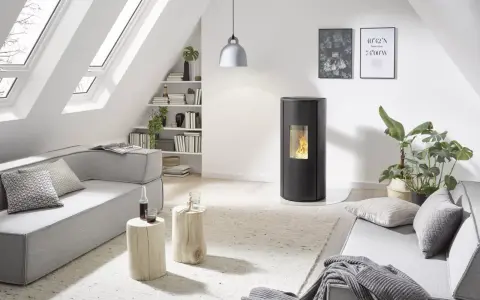 Poêle à granulés Rika en mode confort ou automatique, dans un salon moderne avec canapé gris, table basse en bois et lumière naturelle.
