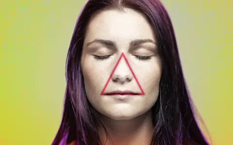 Frauenkopf mit geschlossenen Augen, auf dessen Nase und Mund ein rotes Dreieck liegt. Ein Pickel im Todesdreieck im Gesicht kann gefährlich sein.