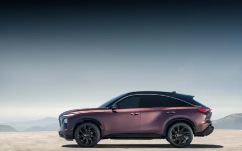 Eleganckie, bordowe infiniti auto z czarnym dachem na tle górskiego krajobrazu.