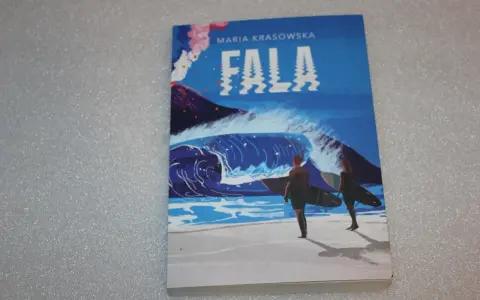 Okładka książki "Fala" Marii Krasowskiej. Dwie osoby z deskami surfingowymi stoją na plaży, patrząc na ogromną, spienioną falę. W tle wulkan wyrzuca dym.