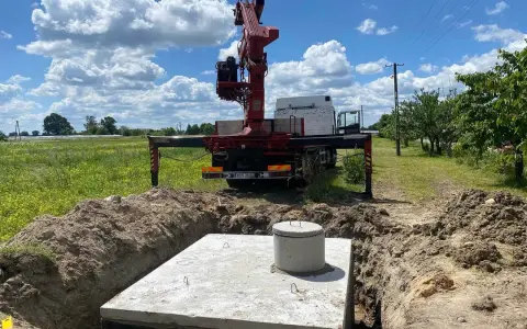 Montaż szamba betonowego w wykopie. Dostępne różne rodzaje szamb, ten jest w trakcie instalacji.