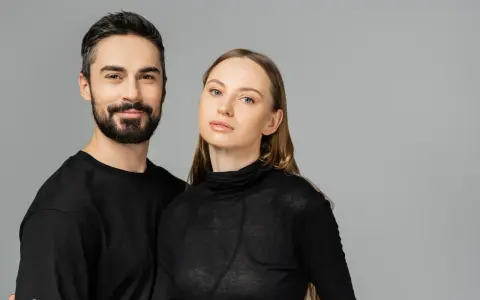 Para, która wygląda jakby mogła nosić ubrania unisex. On z brodą, ona z długimi włosami, oboje w czerni.
