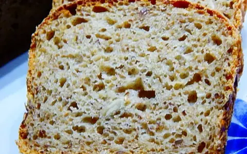 Pyszny chleb żytni na maślance, z widocznymi ziarnami, pokrojony w kromki. Idealny na śniadanie.