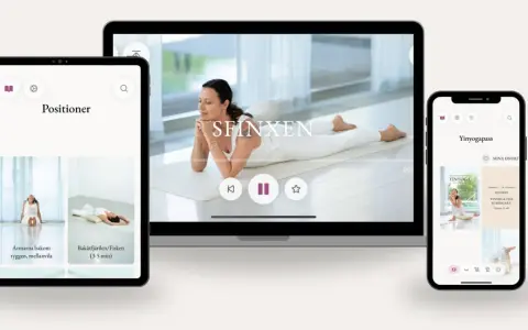 En kvinna utför morgon yoga på en matta. Skärmar visar yogaövningar och pass.