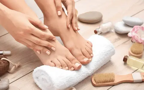 Pied sec que faire ? Mains douces caressant des pieds soignés, entourés d'accessoires de spa.