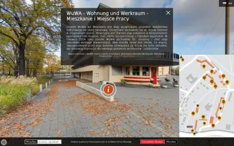 Jesienne liście na chodniku przed osiedlem WuWA we Wrocławiu. W tle budynek i drzewa. Mapa pokazuje rozmieszczenie budynków.