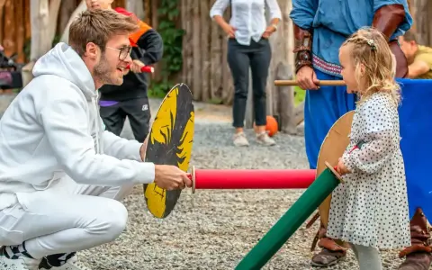 Chłopiec i dziewczynka ćwiczą walkę na miecze. Widać, że dziewczynka ma odwagę i determinację, co są jej mocne strony.
