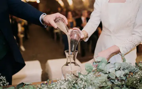 Manos unidas en el ritual de la arena boda, mezclando sus vidas en un solo recipiente.