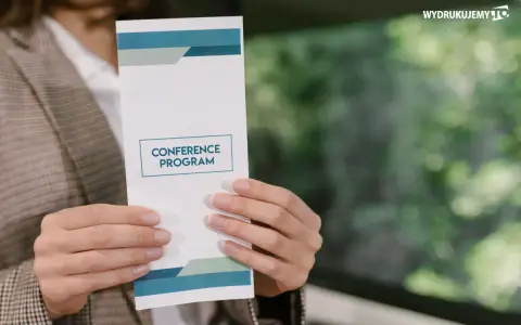 Oto jak wygląda ulotka z programem konferencji, trzymana w dłoniach.