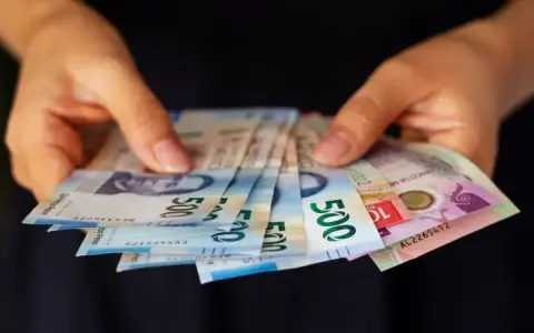 Manos sostienen billetes de 500 pesos, una forma de sacar dinero sin tarjeta.