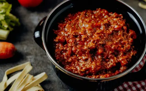 Herzhafte bolognese italienisch Soße in einem Topf, dane frische Pasta, Karotte und Sellerie.