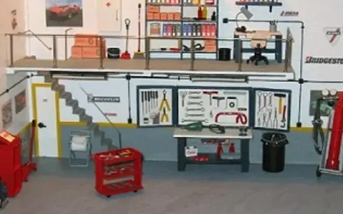 Un taller listo para organizar. Herramientas, estanterías y un coche en miniatura.