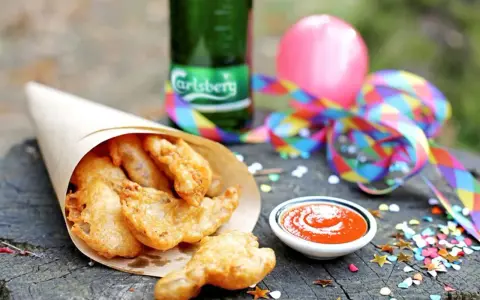 Chrupiące kąski w papierowym rożku, butelka Carlsberg i kolorowe konfetti. Idealne na imprezę!