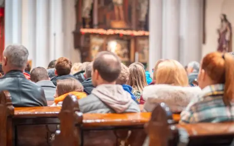 Ludzie siedzą w kościele, słuchając kazania. Wszyscy otrzymują błogosławieństwo, składając życzenia na bierzmowanie.