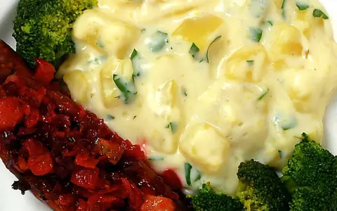 En tallrik med isterband, potatisgratäng och broccoli. Perfekt för ett gott isterband recept.