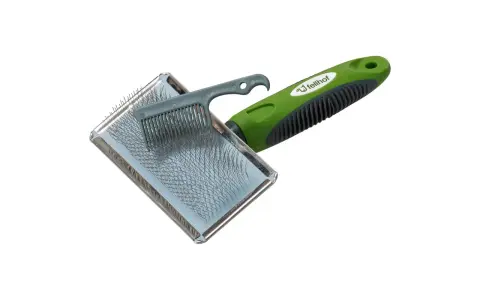 Bürste mit grünem Griff für die Fellpflege. Ideal, um das Lammfell zu pflegen und Verfilzungen zu lösen.