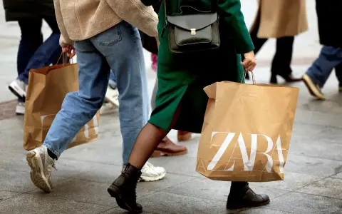 Ludzie idący z torbami ZARA. Może to zakupy, a może zwroty.