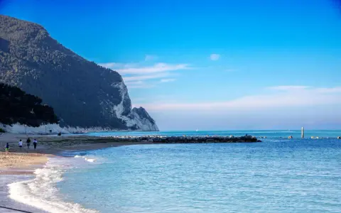 Spiaggia con scogliere e mare azzurro, ideale per scoprire dove andare al mare nelle Marche.