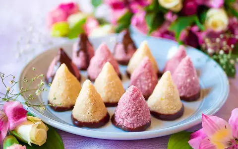 Konformade kokosbollar, några doppade i choklad, andra i rosa strössel. Perfekt för att baka utan ugn en solig dag.