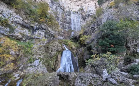 Impresionante cascada en la ruta de las cascadas Bogarra, cayendo por una pared rocosa con vegetación otoñal.