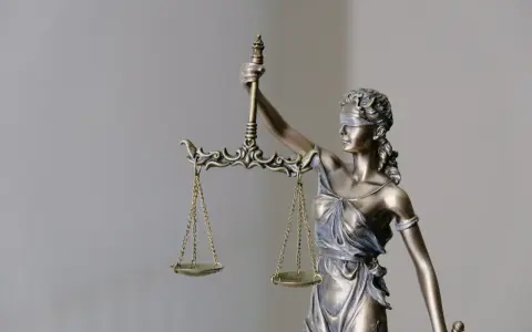 Figurka Temidy z wagą. Czy syndyk sprawdza historię rachunku? Sprawiedliwość waży dowody.