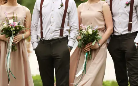 Eleganckie stroje pary z bukietami. Brak informacji o dress codzie na zaproszeniu mógłby prowadzić do takich stylizacji.