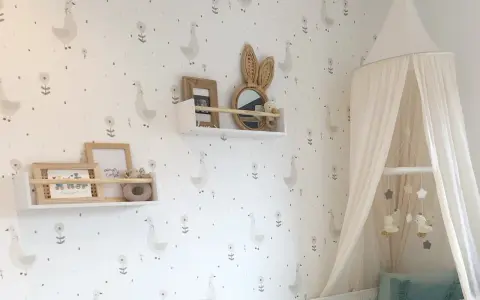 Habitaciones con papel pintado y pintura de patitos y flores. Un dosel de cama blanco cuelga sobre una cuna.