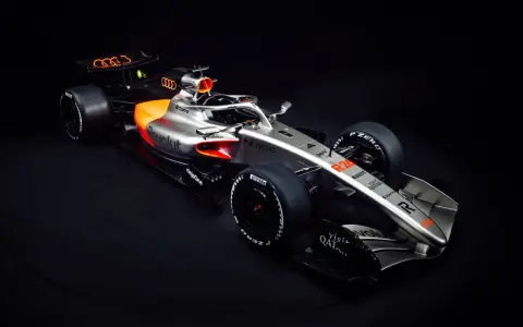Ein silberner und oranger Audi F1 Auto mit dem Audi-Logo auf dem Heckflügel.