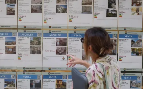 Mujer señalando anuncios de alquiler y venta de inmuebles, buscando opciones para el bono joven alquiler.