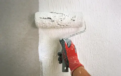 Mit einem speziellen Roller wird eine Strukturpaste aufgetragen, um eine interessante Wandgestaltung zu erzielen. Das Ergebnis erinnert an **Styropor spachteln** für eine einzigartige Textur.